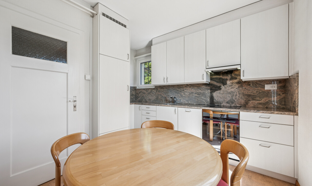küche mit dark countertops, white cabinets, weiße schränke, inside property, und küchenrückwand beim Herd