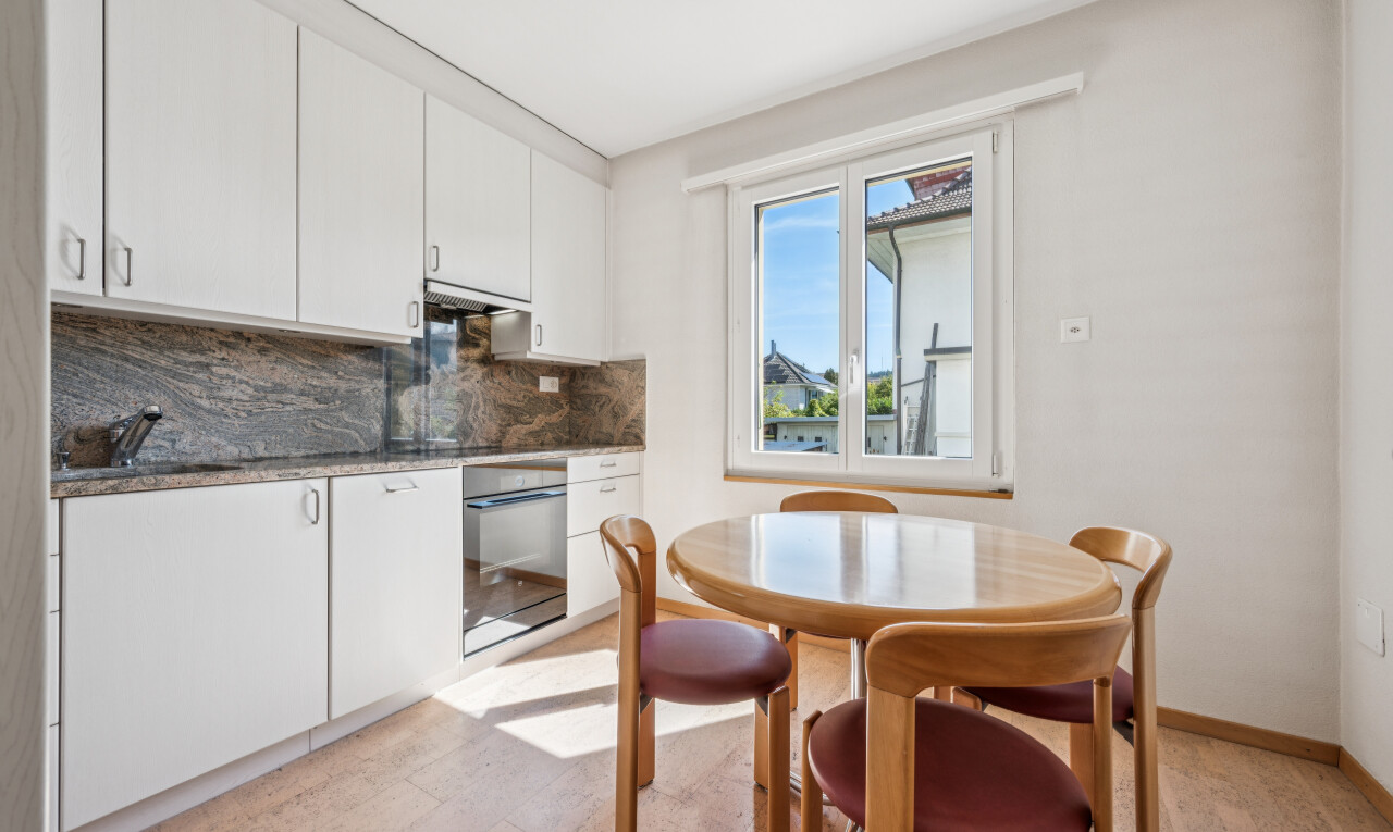 küche mit weiße schränke, white cabinets, light floor, ofen, und dark countertops