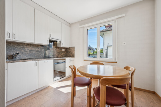 küche mit weiße schränke, white cabinets, light floor, ofen, und dark countertops