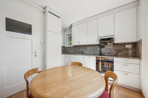 küche mit dark countertops, white cabinets, weiße schränke, inside property, und küchenrückwand beim Herd