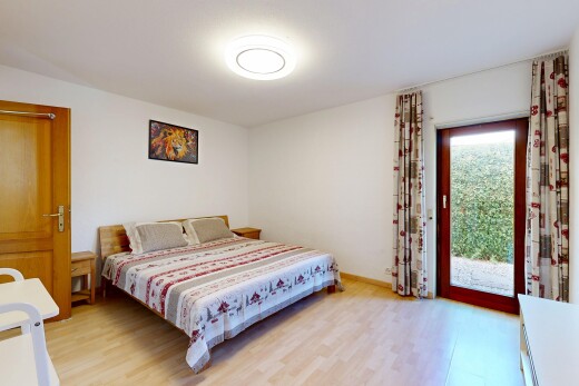 zimmer / schlafzimmer mit außenzugang, holzfußboden, gipskartonwand, und natürliches licht