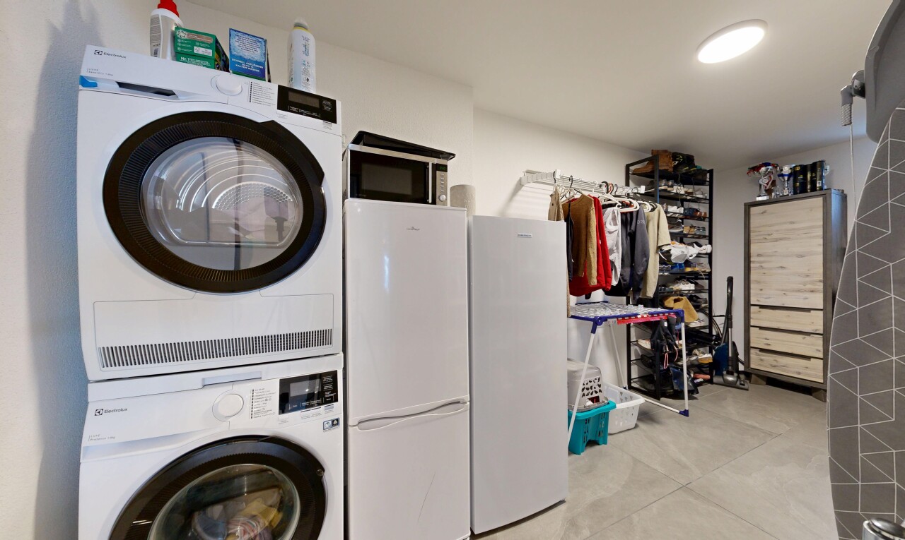 buanderie avec inside property, lave-linge et sèche-linge superposés, et buanderie