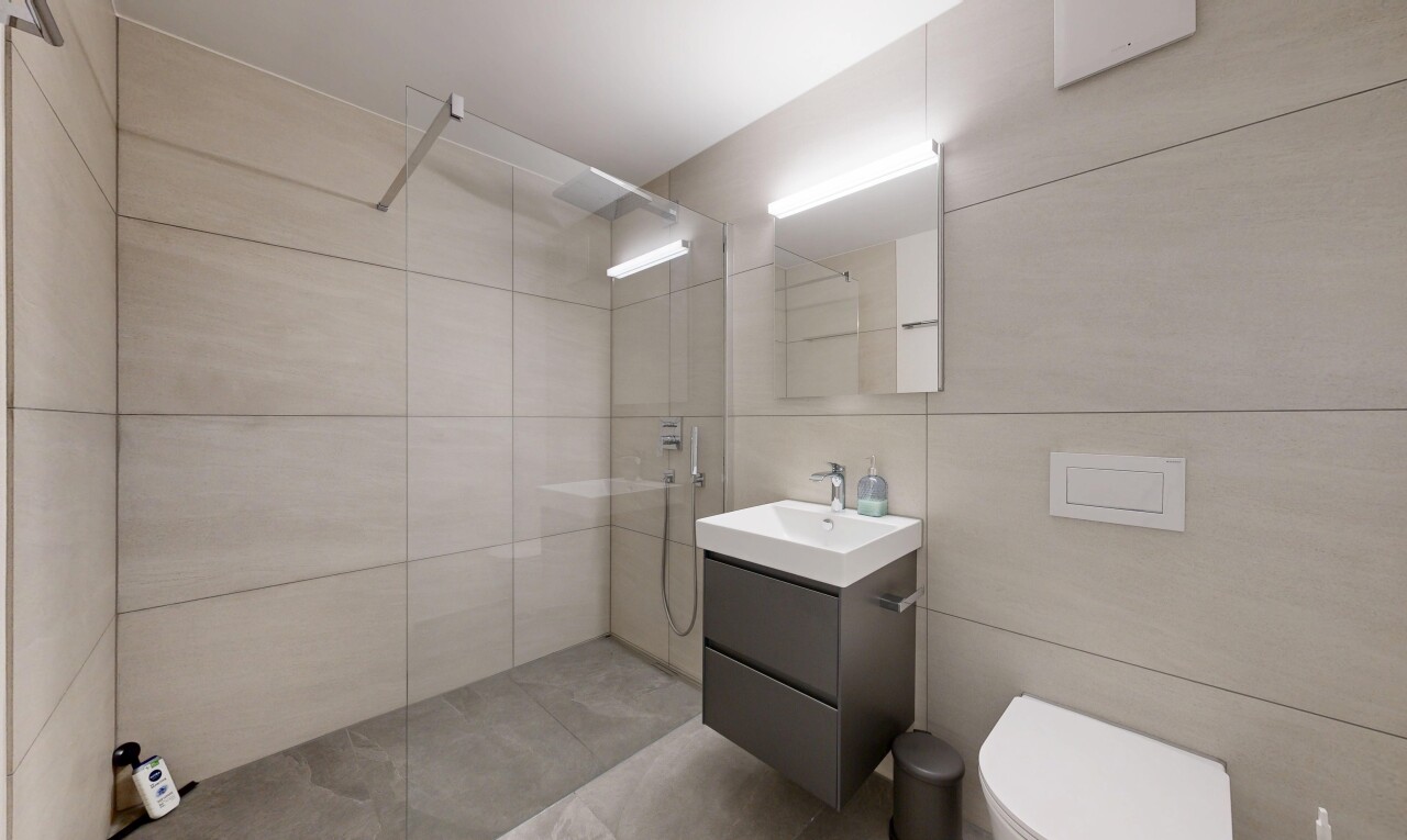 salle de bains avec miroir, lavabo (ou coiffeuse selon le contexte), douche, salle de bain complète, et inside property