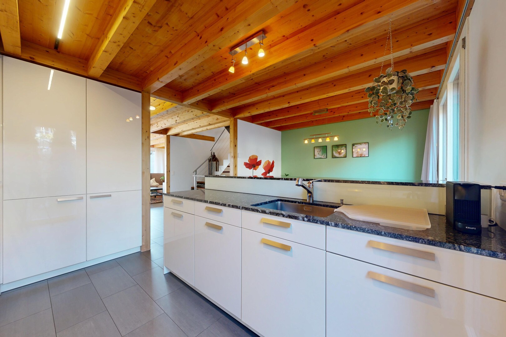 cuisine avec two heights countertops, dark countertops, plans de travail en pierre, stone countertops, et inside property