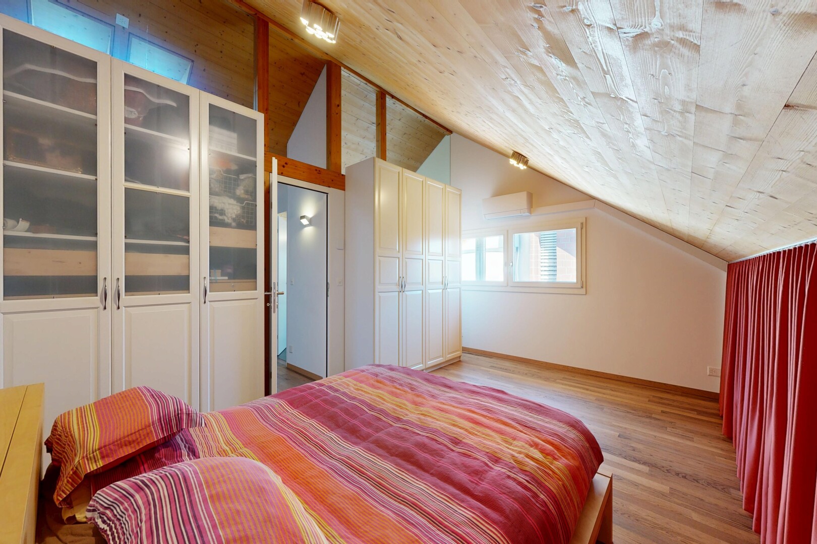 chambre avec plafond voûté, vaulted ceiling, sol en finition bois, wood finish floor, et lumière naturelle