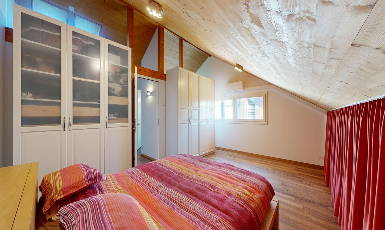 chambre avec plafond voûté, vaulted ceiling, sol en finition bois, wood finish floor, et lumière naturelle