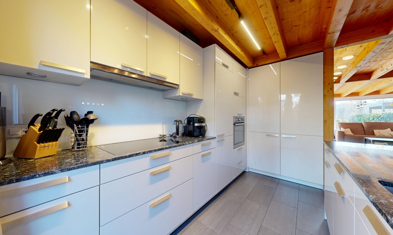 cuisine avec dark countertops, plans de travail en pierre, stone countertops, inside property, et armoires blanches