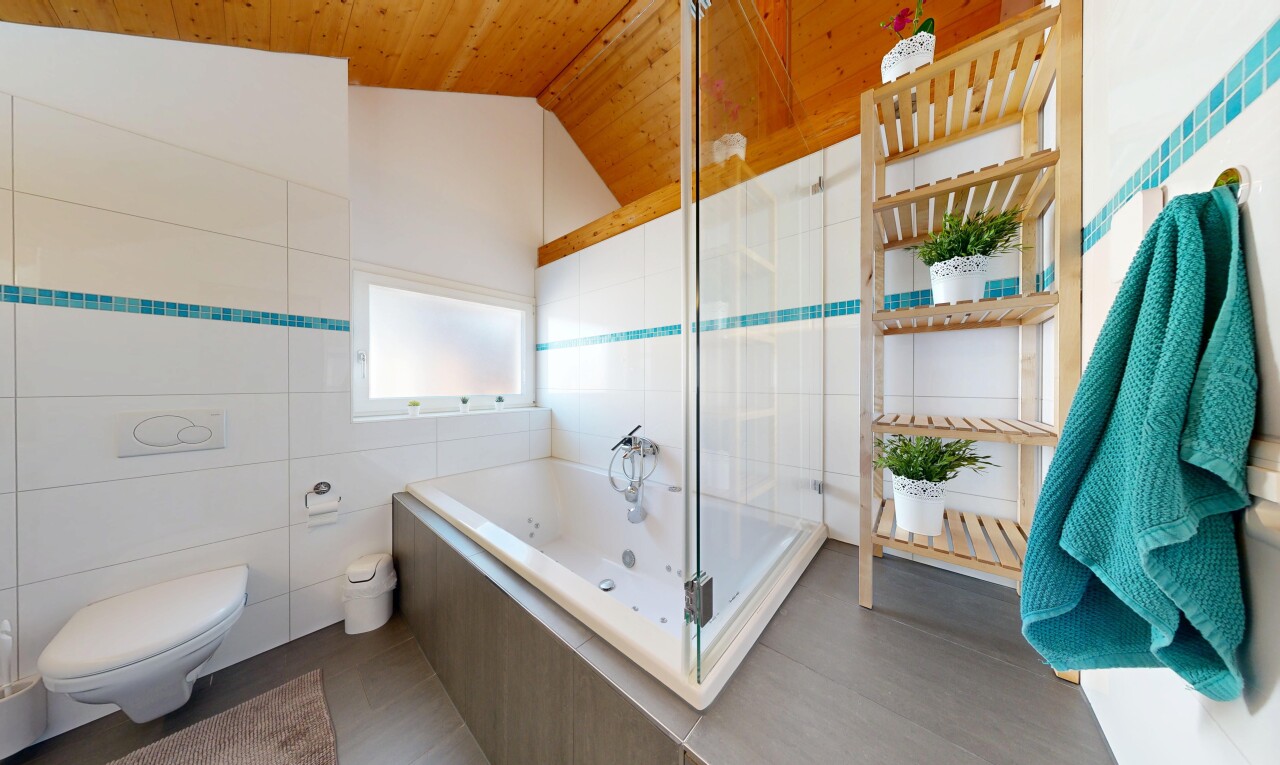 salle de bains avec salle de bain complète, tile wall, mur en carrelage, inside property, et vaulted ceiling