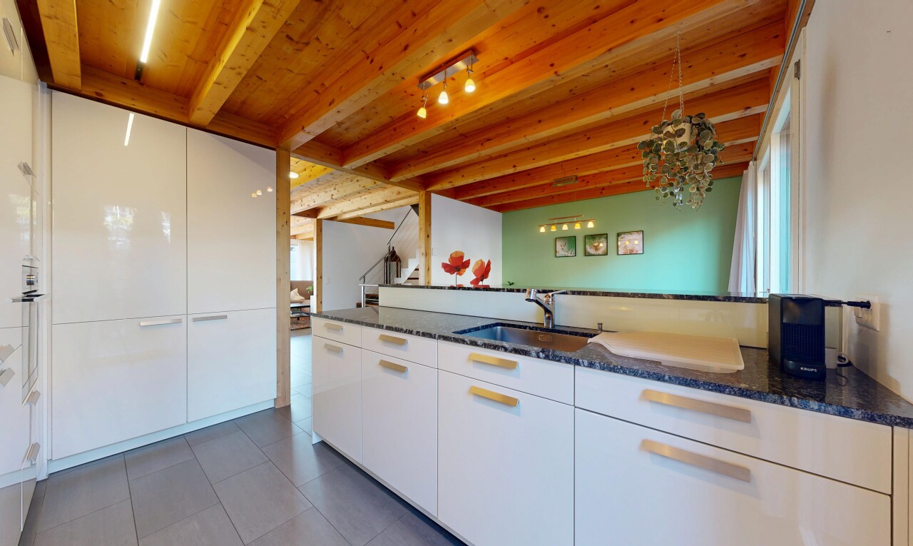 cuisine avec two heights countertops, dark countertops, plans de travail en pierre, stone countertops, et inside property
