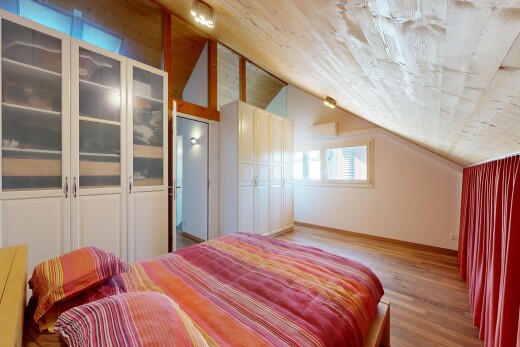 chambre avec plafond voûté, vaulted ceiling, sol en finition bois, wood finish floor, et lumière naturelle