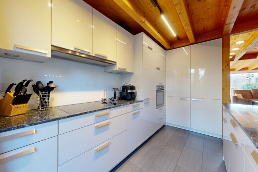 cuisine avec dark countertops, plans de travail en pierre, stone countertops, inside property, et armoires blanches