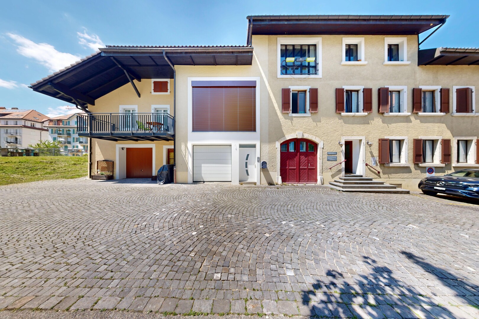 außenansicht mit day time, eingebaute garage, stuckverkleidung, und auffahrt
