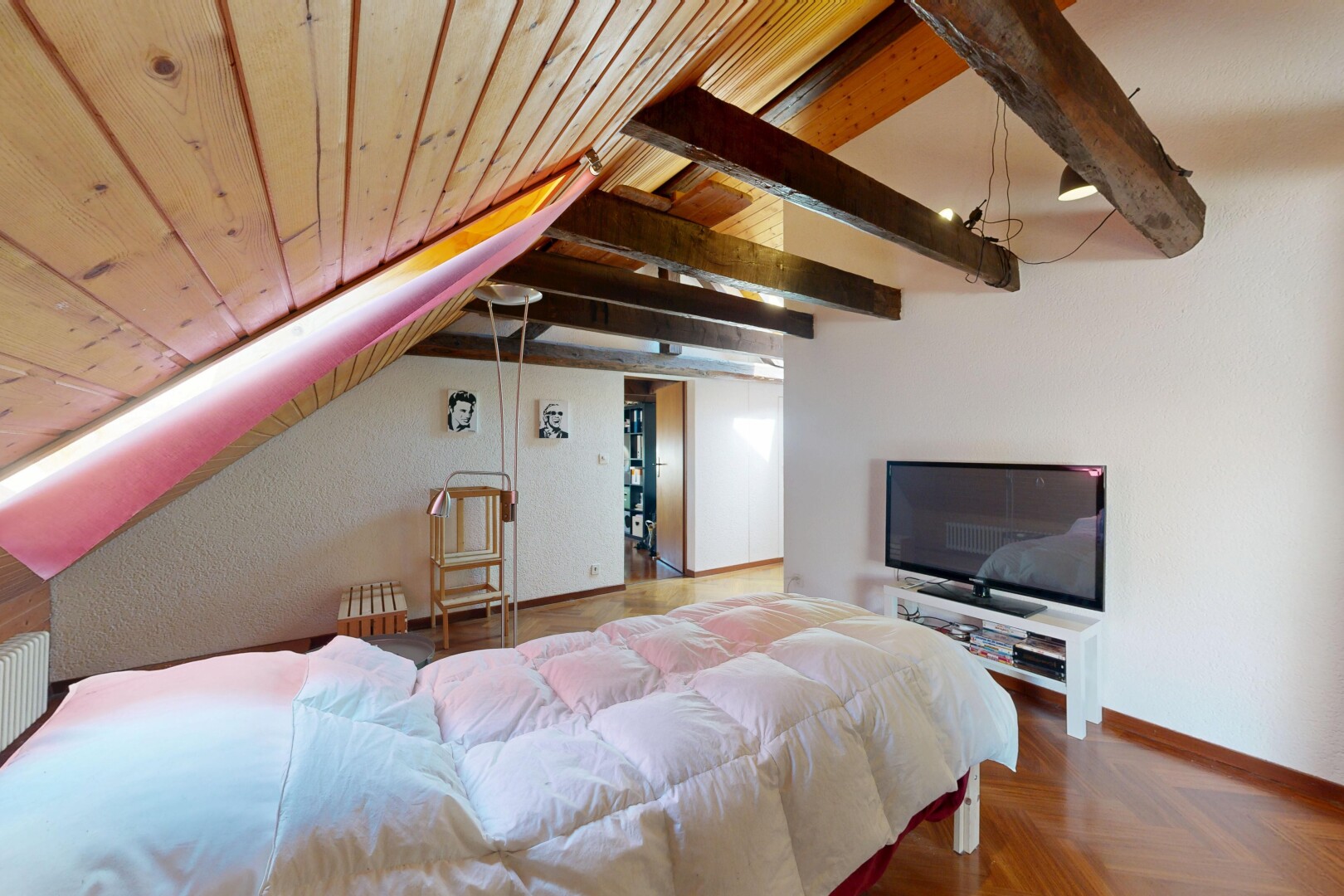 zimmer / schlafzimmer mit dachschräge, vaulted ceiling, fernseher, inside property, und holzfußboden