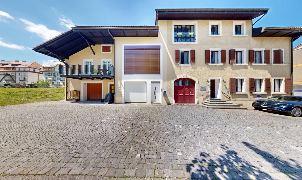 außenansicht mit day time, eingebaute garage, stuckverkleidung, und auffahrt