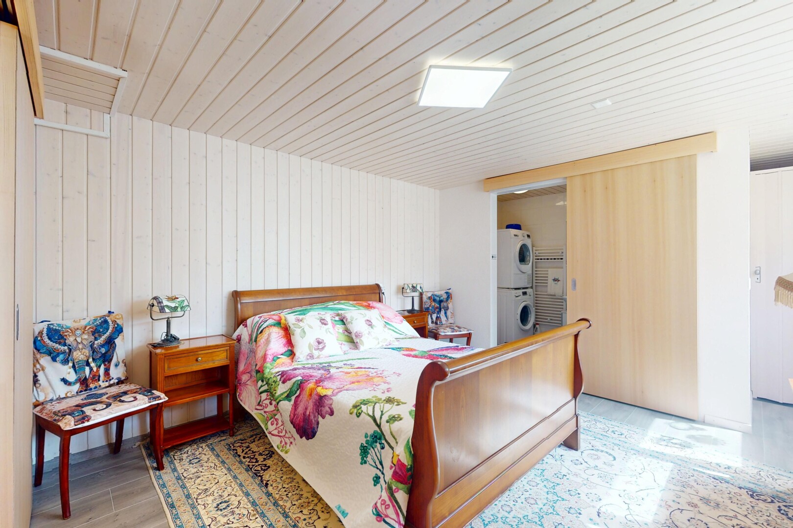 chambre avec lave-linge et sèche-linge superposés, inside property, wood finish floor, sol en finition bois, et wood wall