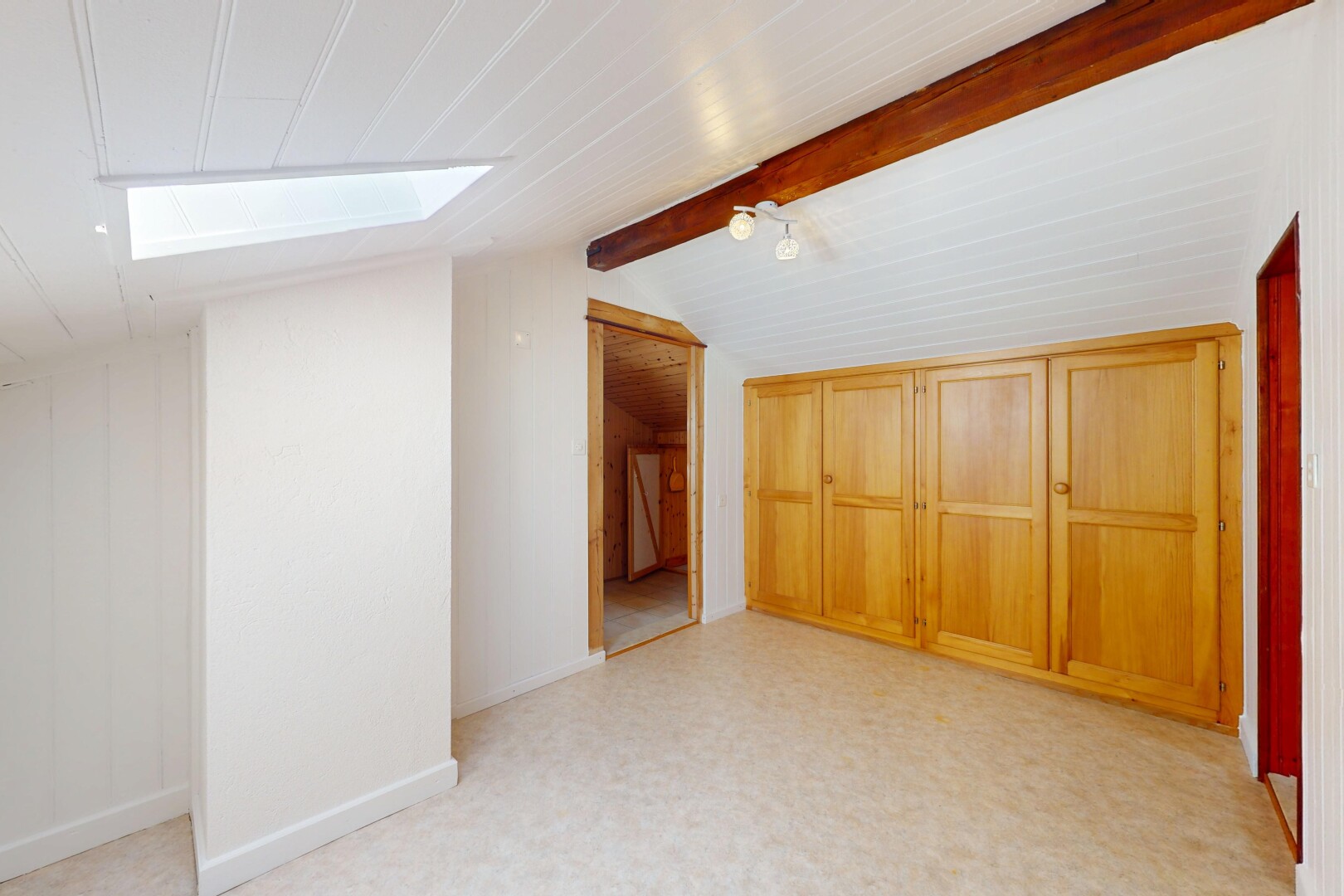 pièce vide avec inside property, vaulted ceiling, plafond voûté, beamed ceiling, et plafond à poutres