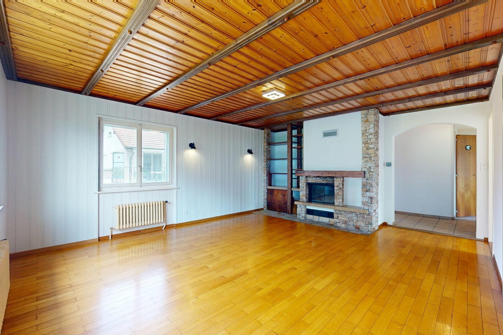 pièce vide avec wood finish floor, sol en finition bois, inside property, radiateur, et cheminée