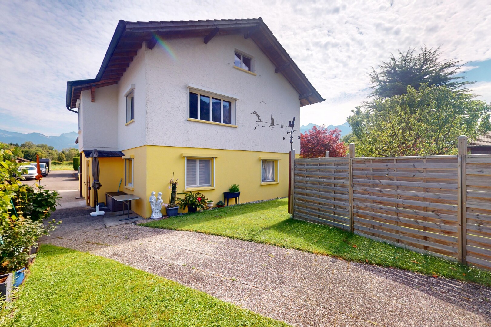 façade avec property visible, clôture, bardage en stuc, pelouse, et day time