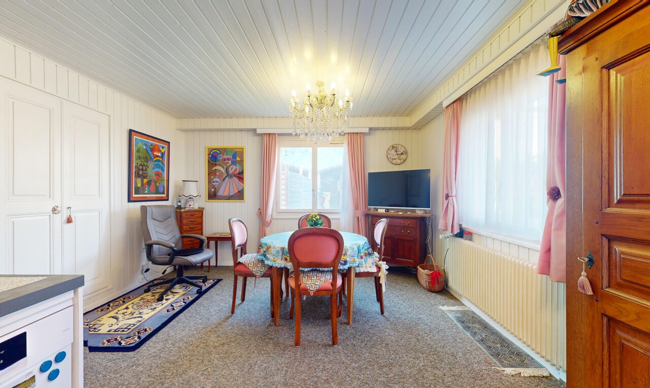 salle à manger avec lustre remarquable, natural light, lumière naturelle, télévision, et carpet