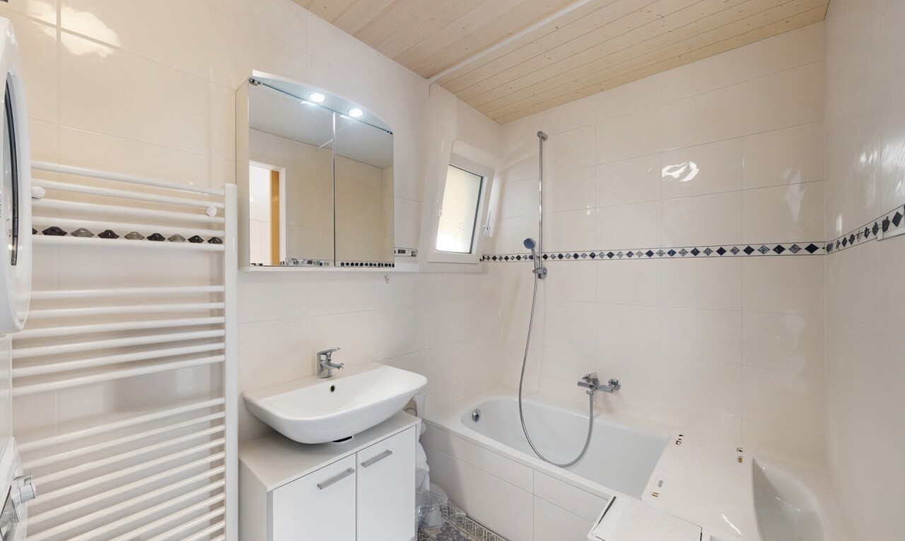 salle de bains avec tile wall, mur en carrelage, radiateur, chauffe-serviettes, et inside property