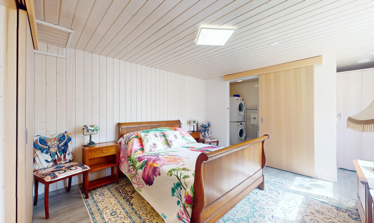 chambre avec lave-linge et sèche-linge superposés, inside property, wood finish floor, sol en finition bois, et wood wall