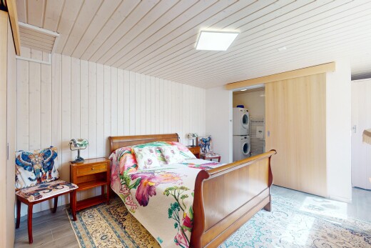 chambre avec lave-linge et sèche-linge superposés, inside property, wood finish floor, sol en finition bois, et wood wall