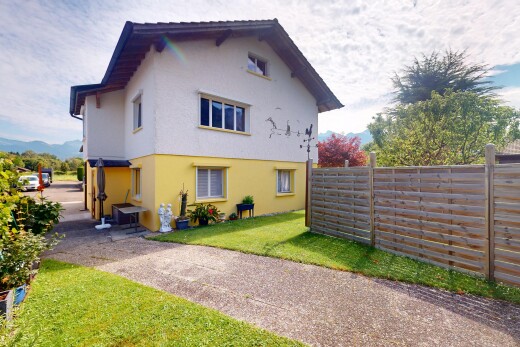 façade avec property visible, clôture, bardage en stuc, pelouse, et day time