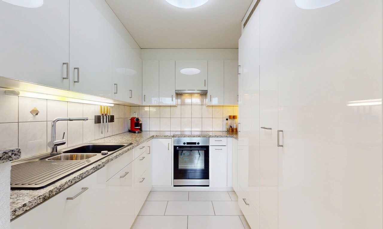 cuisine avec four, light countertops, light floor, plans de travail en pierre, et stone countertops