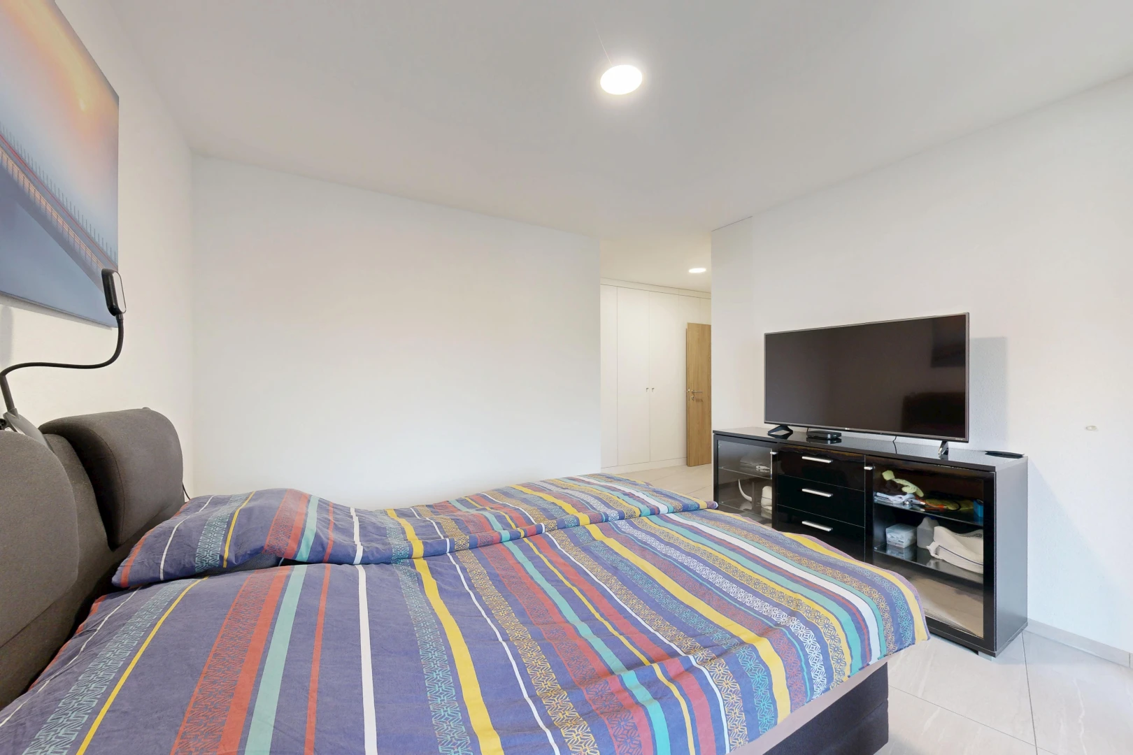 chambre avec télévision, éclairage encastré, cloison sèche, drywall, et light floor