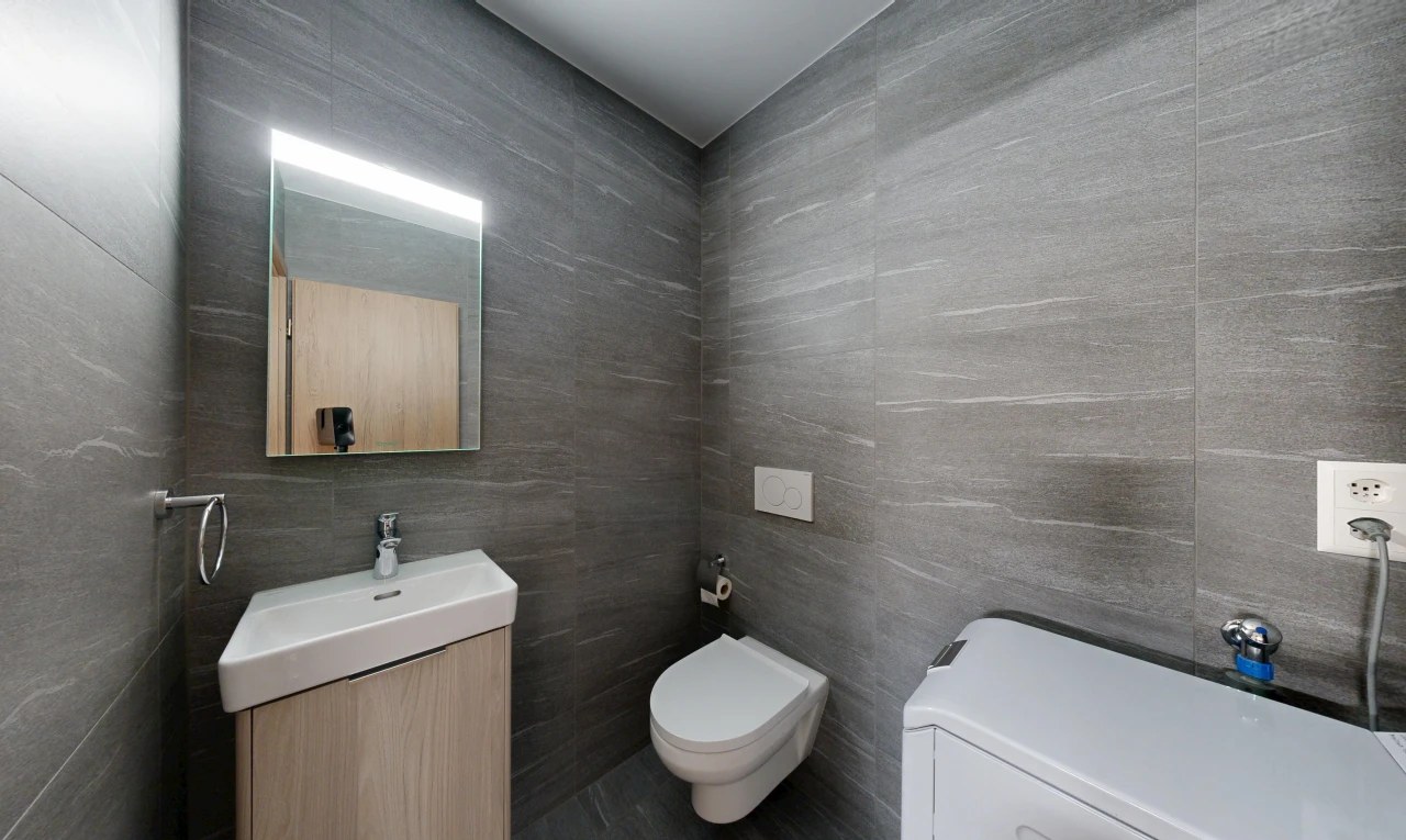 salle de bains avec évier, tile wall, mur en carrelage, toilette, et lavabo (ou coiffeuse selon le contexte)