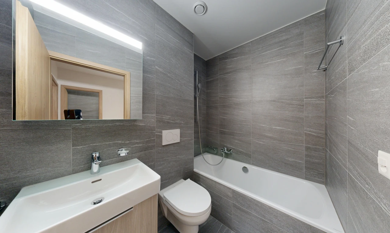 salle de bains avec salle de bain complète, tile wall, mur en carrelage, évier, et miroir