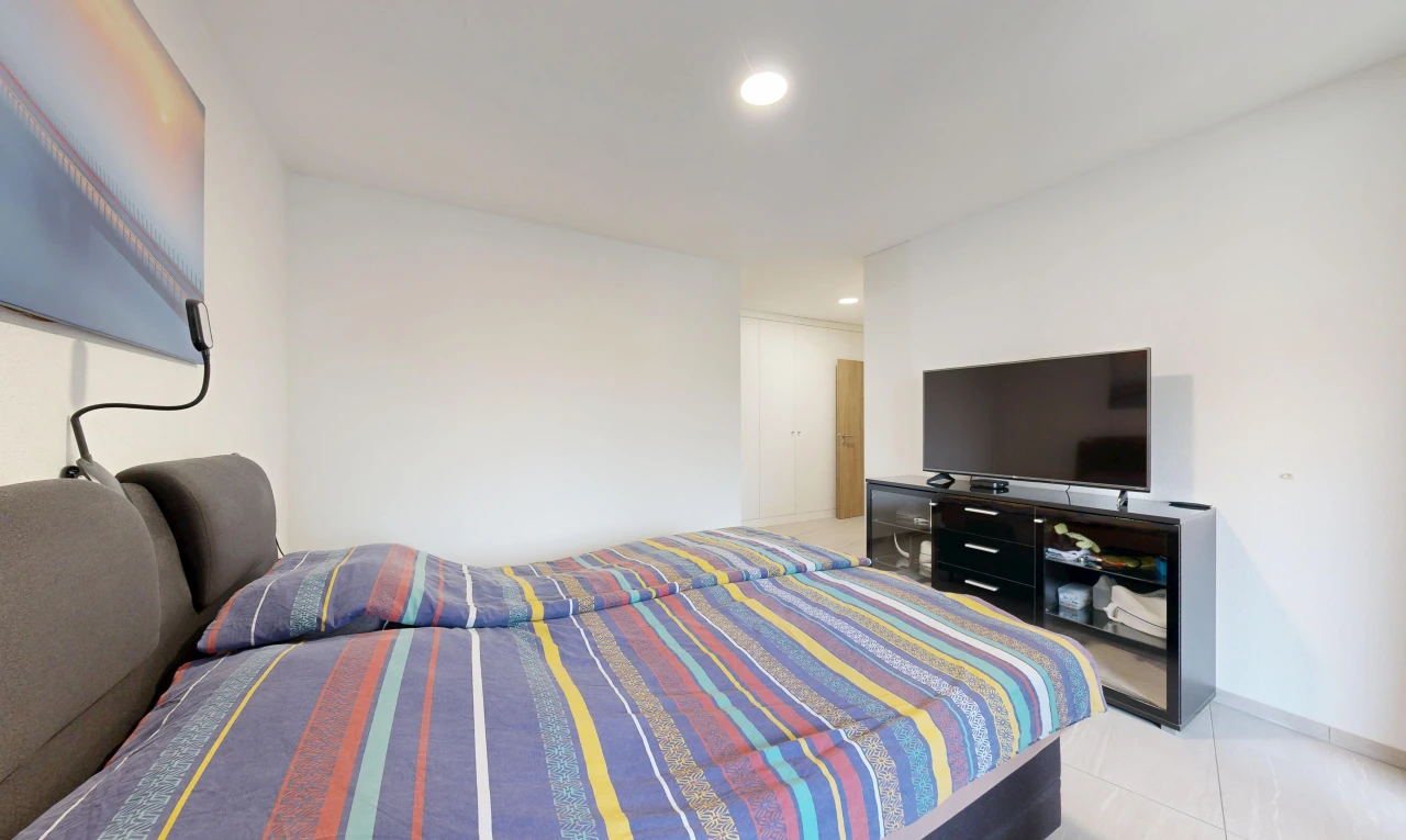 chambre avec télévision, éclairage encastré, cloison sèche, drywall, et light floor