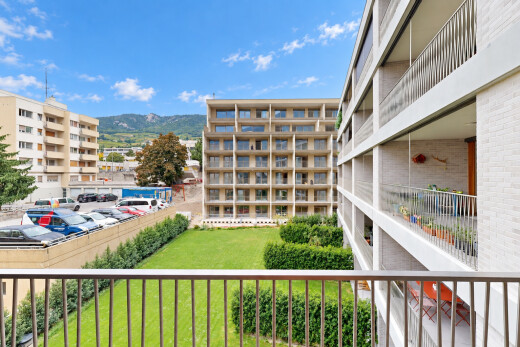 view of property with a mountain view and uncovered parking