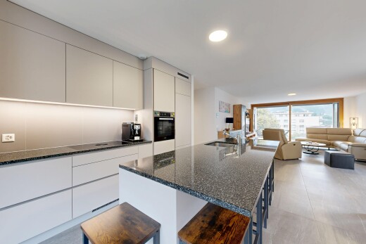 kitchen featuring modern cabinets, open floor plan, dark stone counters, and a kitchen island with sink