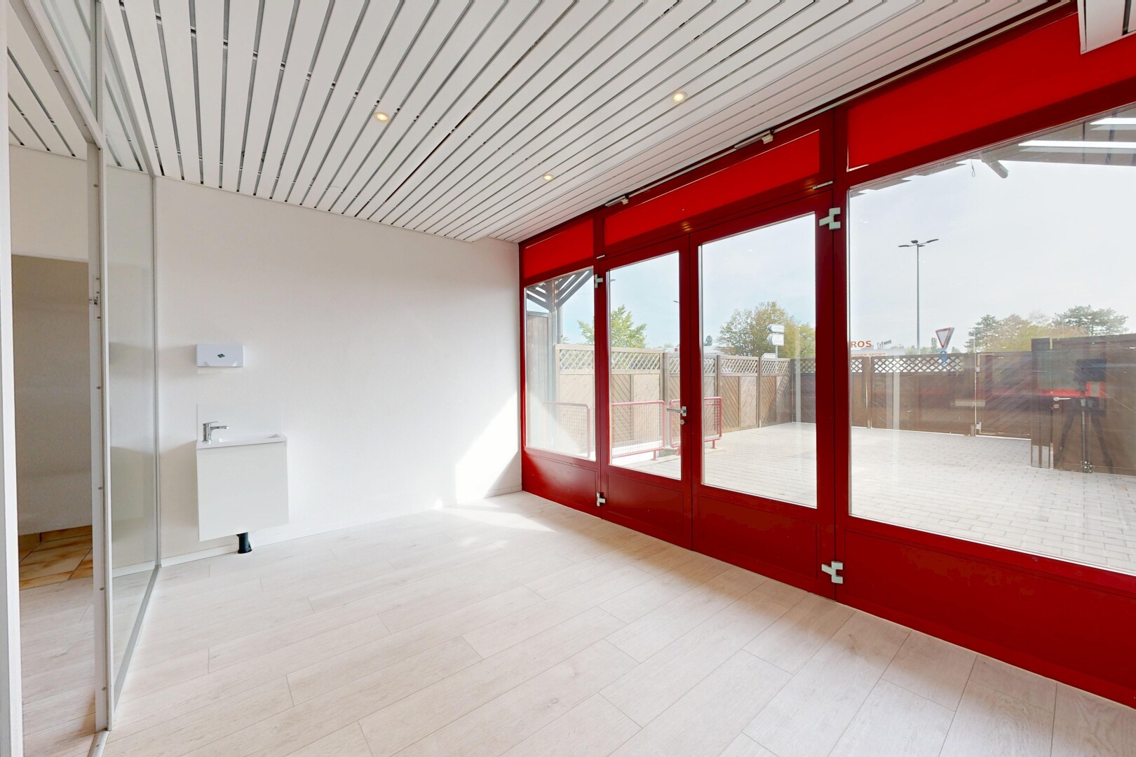 pièce vide avec véranda, drywall, cloison sèche, éclairage encastré, et wood finish floor