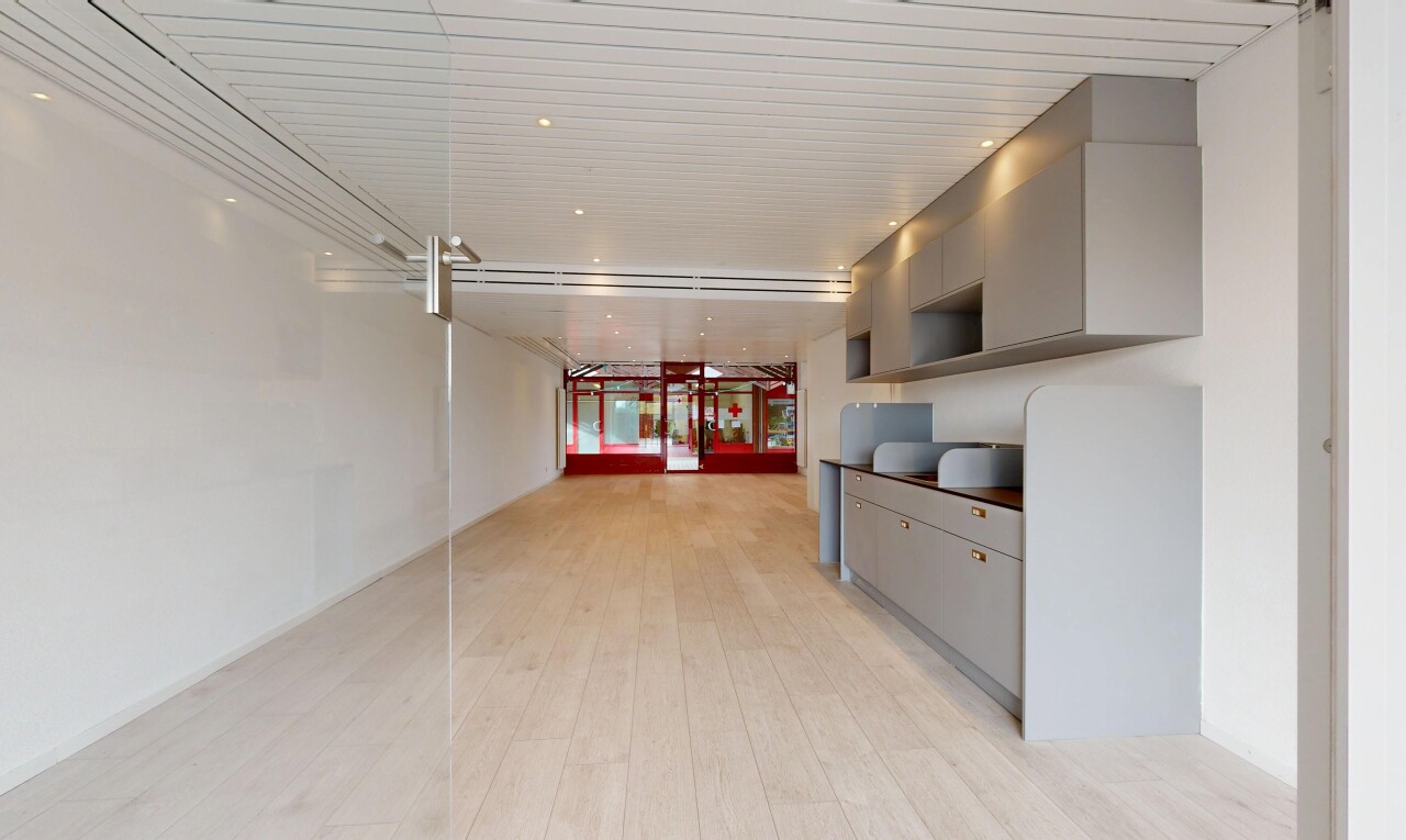 cuisine avec gray cabinets, armoires grises, drywall, wood finish floor, et éclairage encastré