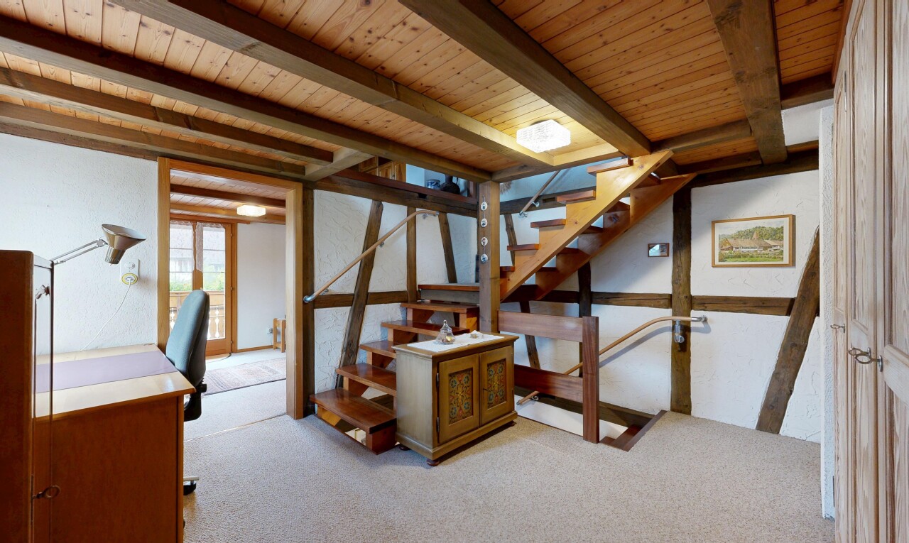 stairway with carpet and beam ceiling
