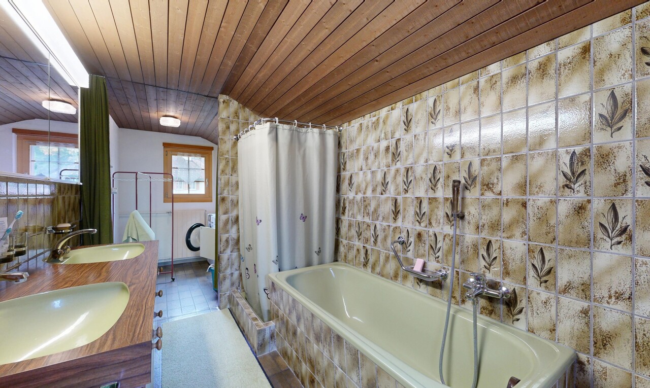 bathroom featuring double vanity, wood ceiling, and tile walls