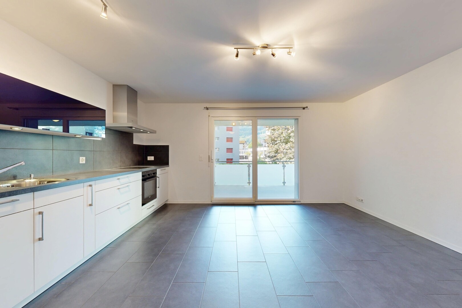 cuisine avec track lighting, éclairage sur rail, white cabinets, armoires blanches, et hotte