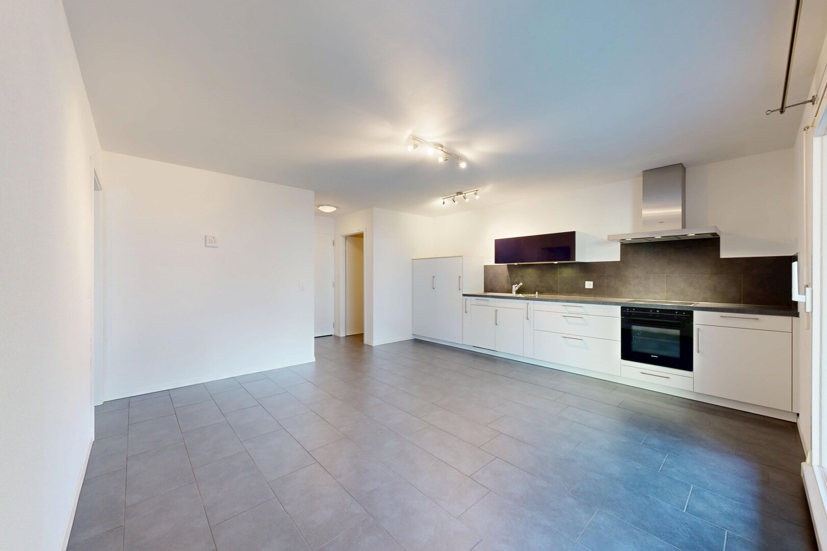 cuisine avec dosseret, backsplash, four, hotte, et inside property