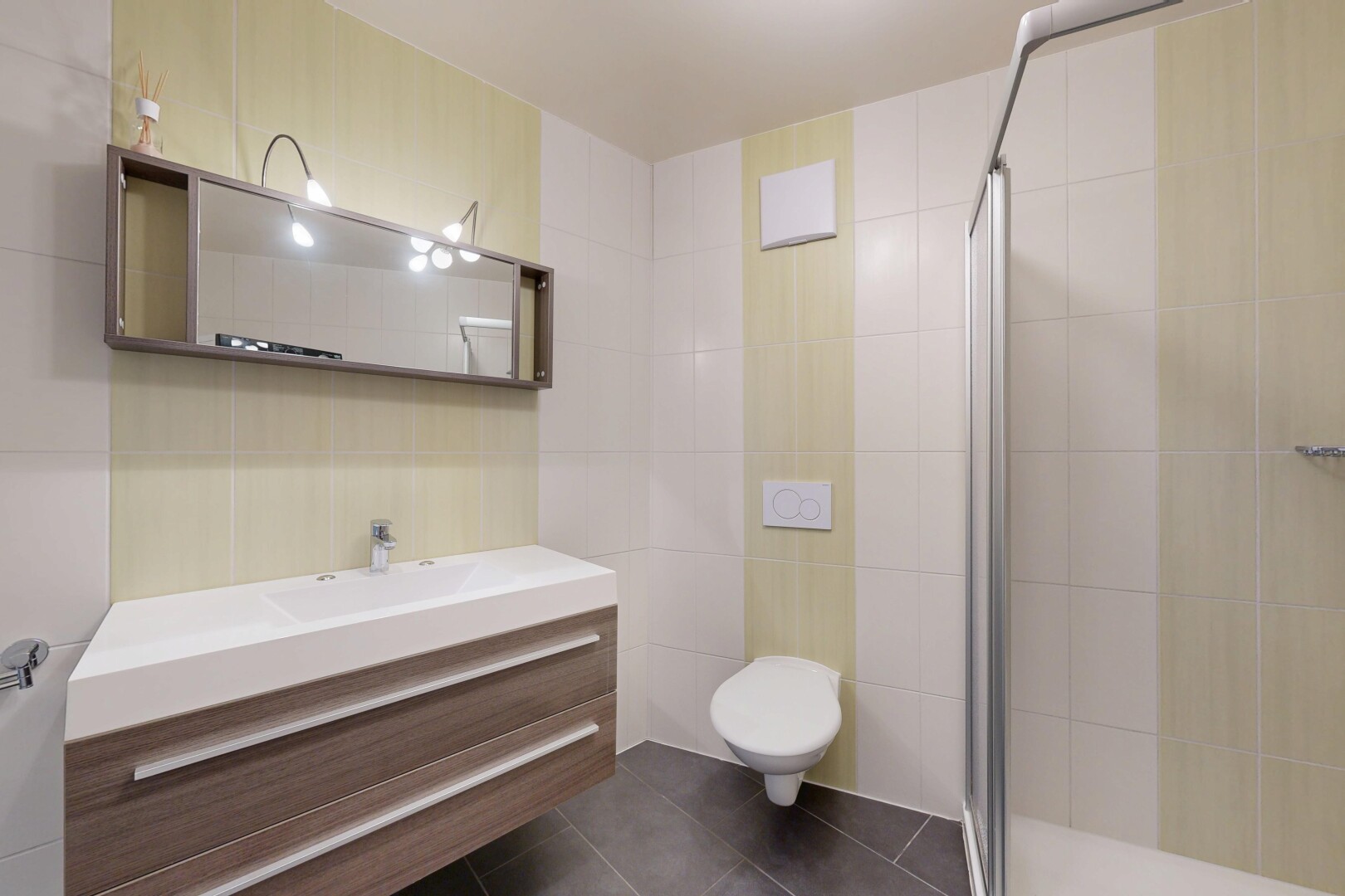salle de bains avec mur en carrelage, tile wall, salle de bain complète, miroir, et dark floor
