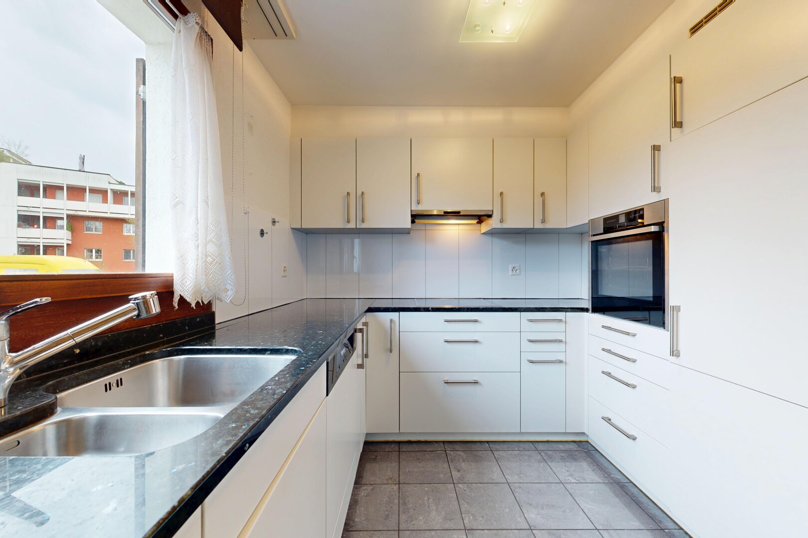 küche mit dark countertops, ofen, weiße schränke, white cabinets, und waschbecken