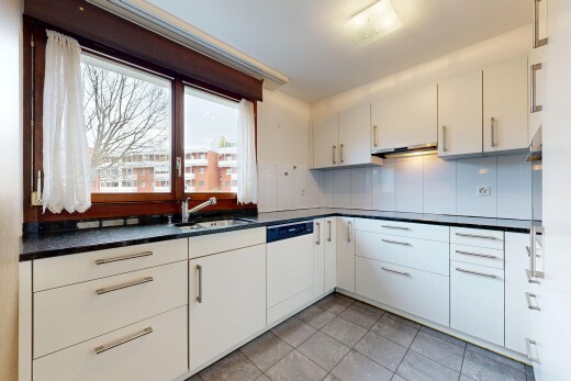 cuisine avec plans de travail, dark countertops, armoires blanches, white cabinets, et lumière naturelle
