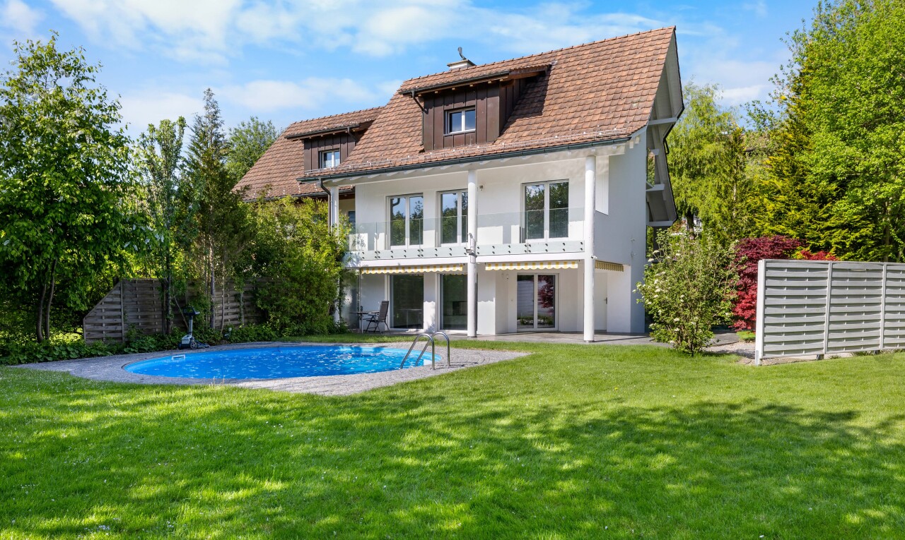 außenansicht mit balkon, rasen, dachgaube, und schwimmbad