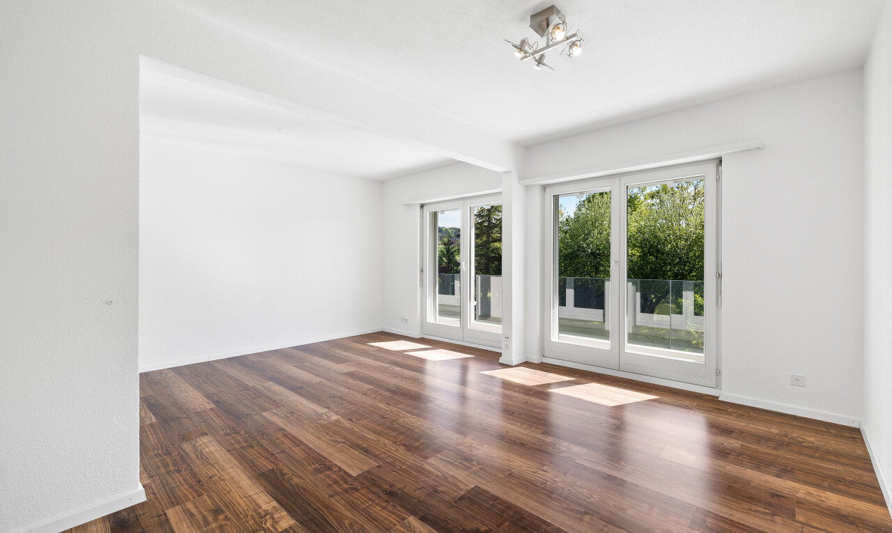 leerer raum mit natürliches licht, sockelleisten, holzfußboden, und gipskartonwand