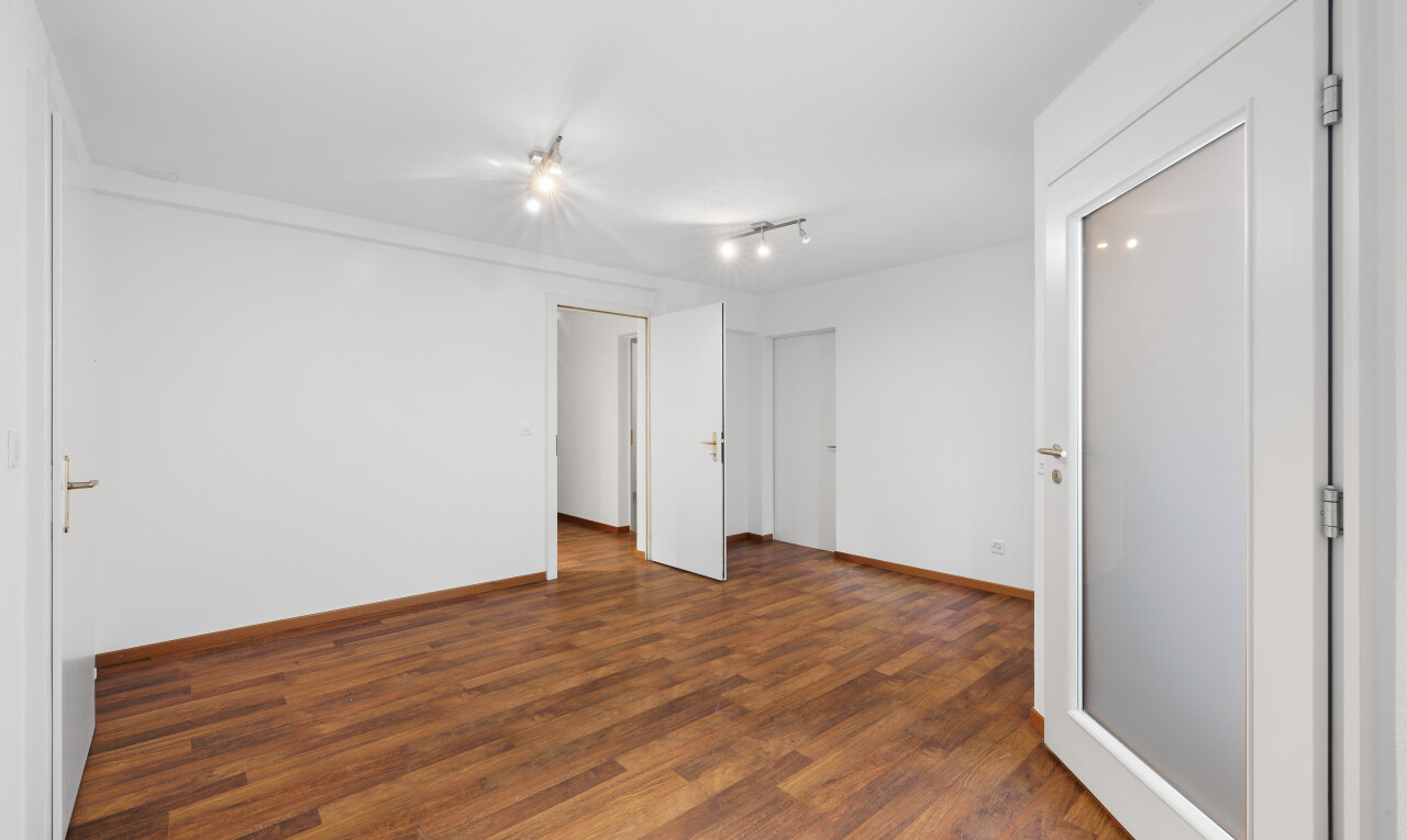 leerer raum mit deckenbeleuchtung, holzfußboden, und gipskartonwand