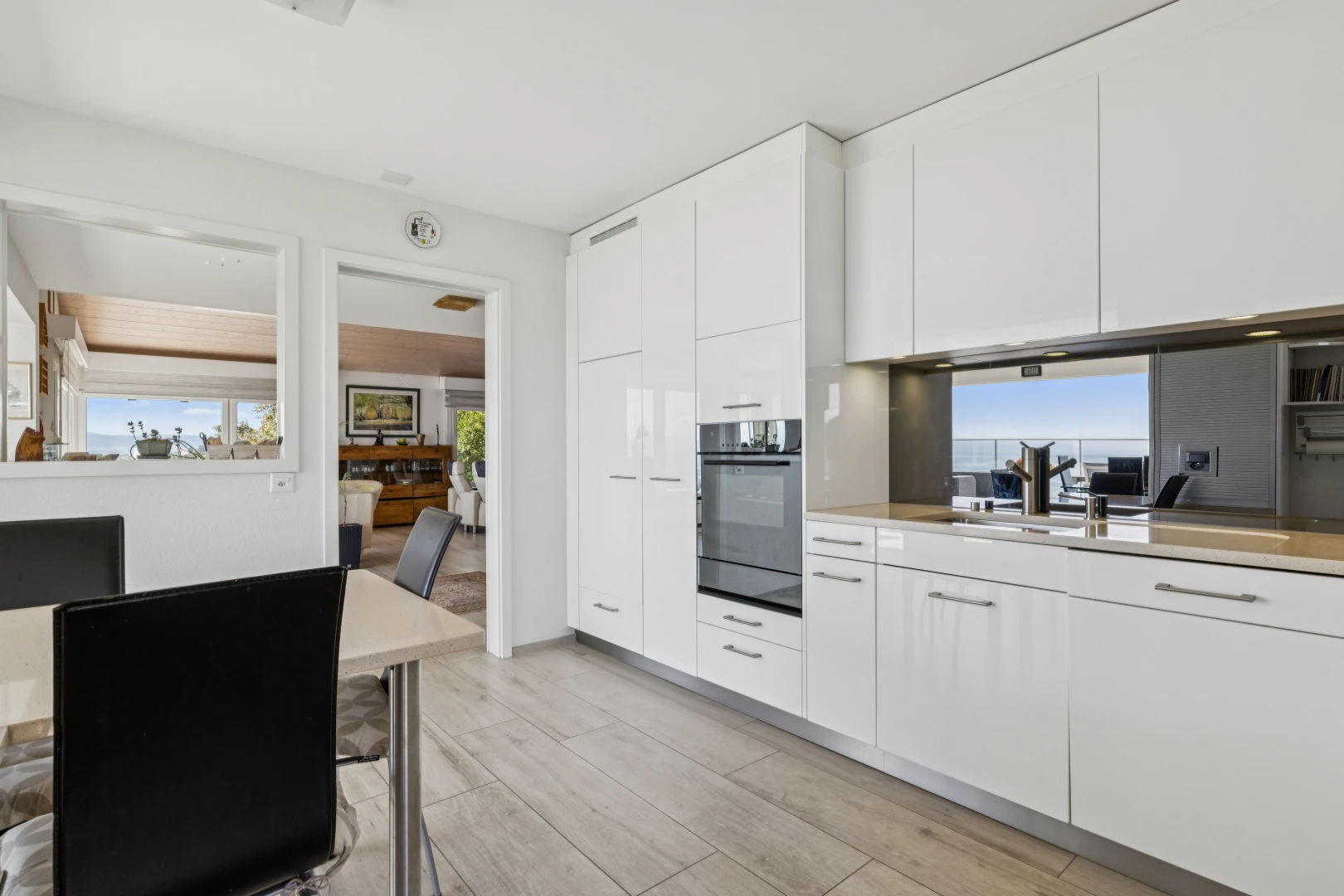 cuisine avec light countertops, plans de travail, white cabinets, armoires blanches, et day time