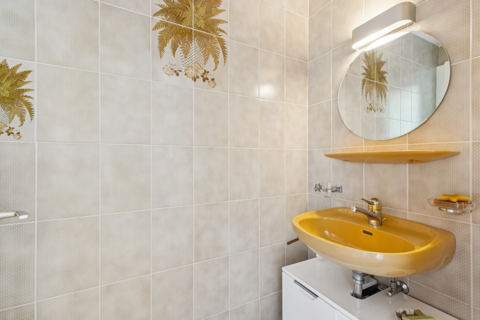 salle de bains avec miroir, évier, mur en carrelage, et tile wall