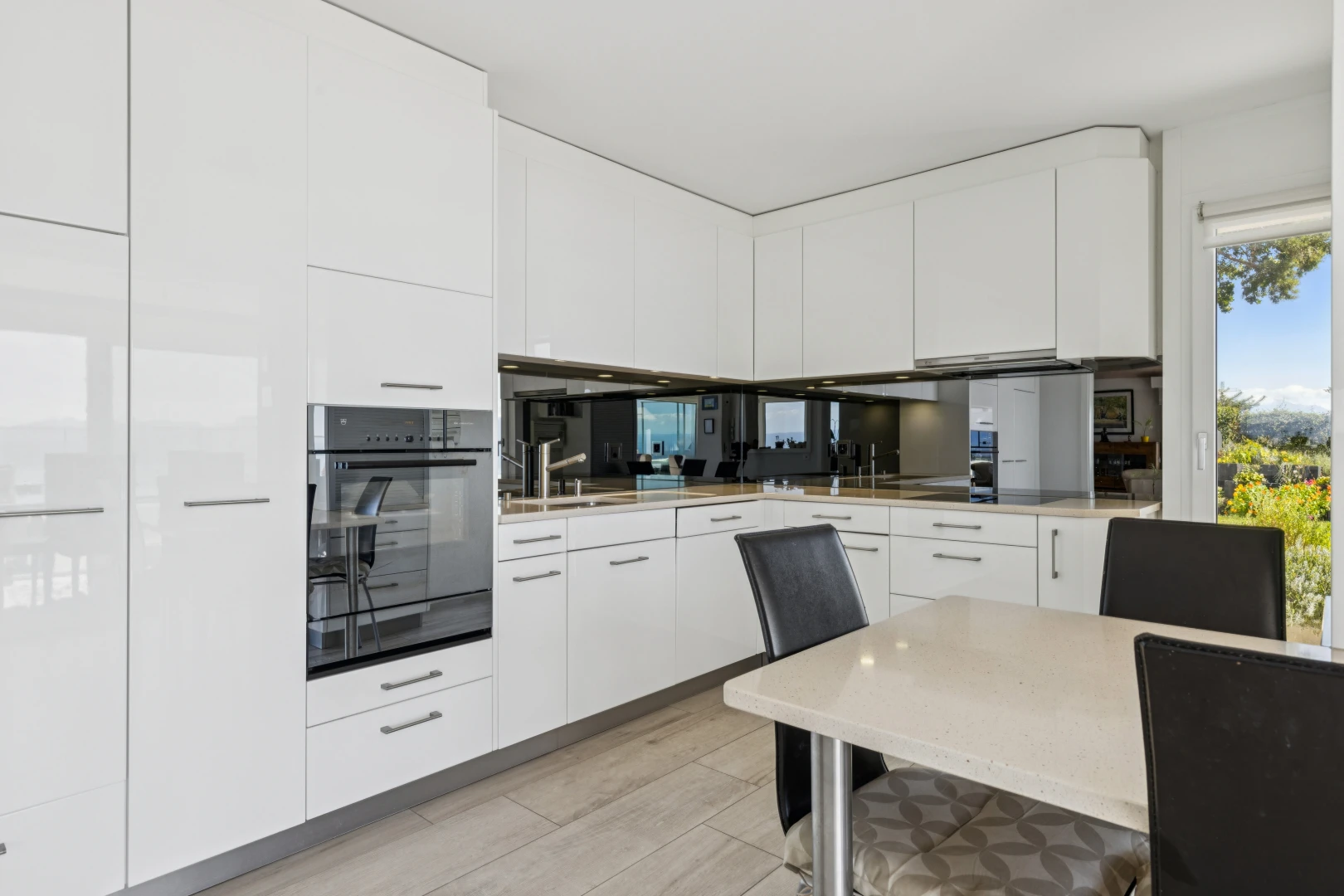 cuisine avec four, armoires blanches, white cabinets, light floor, et plans de travail
