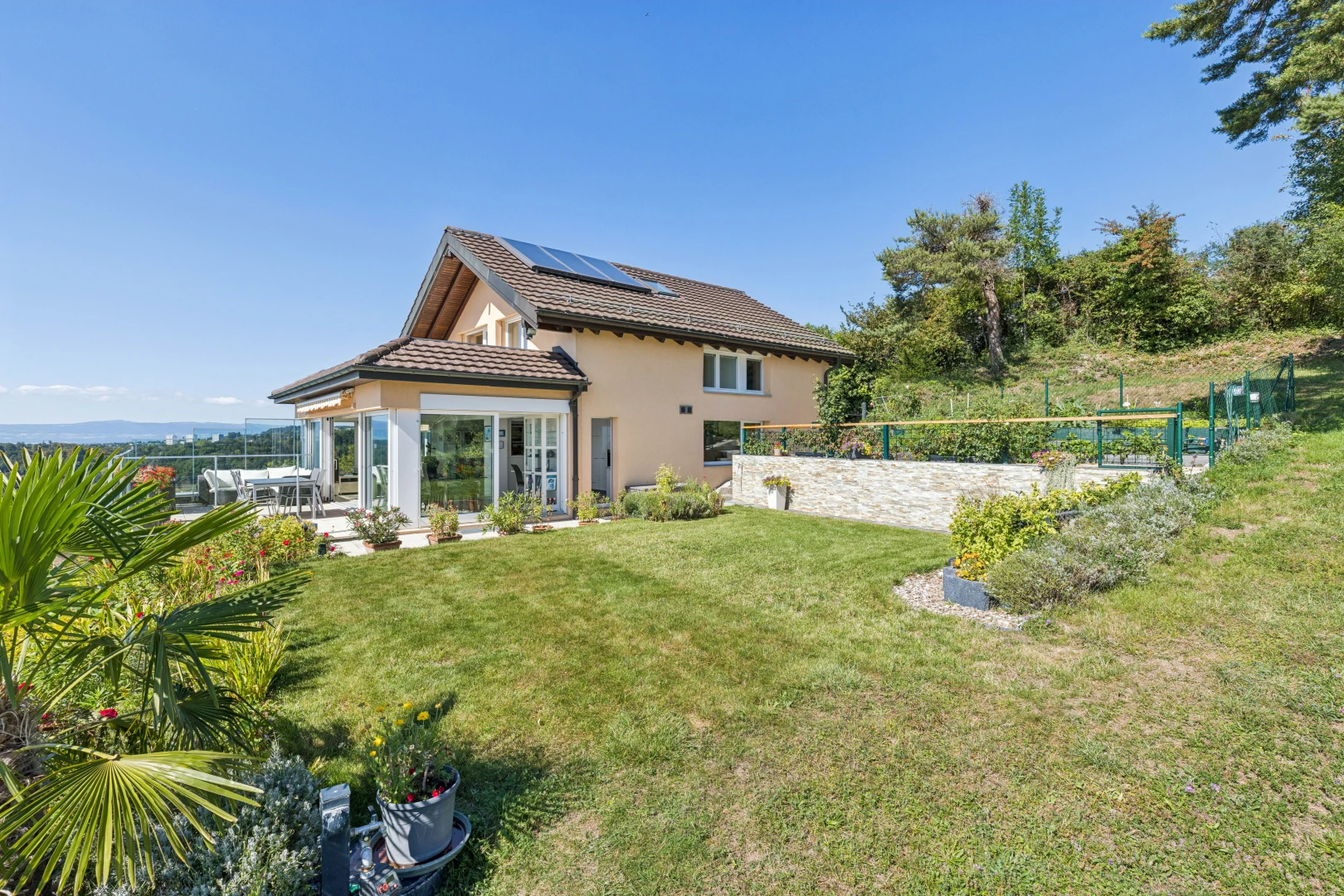 façade avec panneaux solaires, property visible, pelouse, from property, et toit en tuiles
